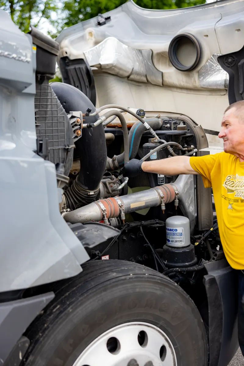 Technician working on semi truck aftertreatment piping