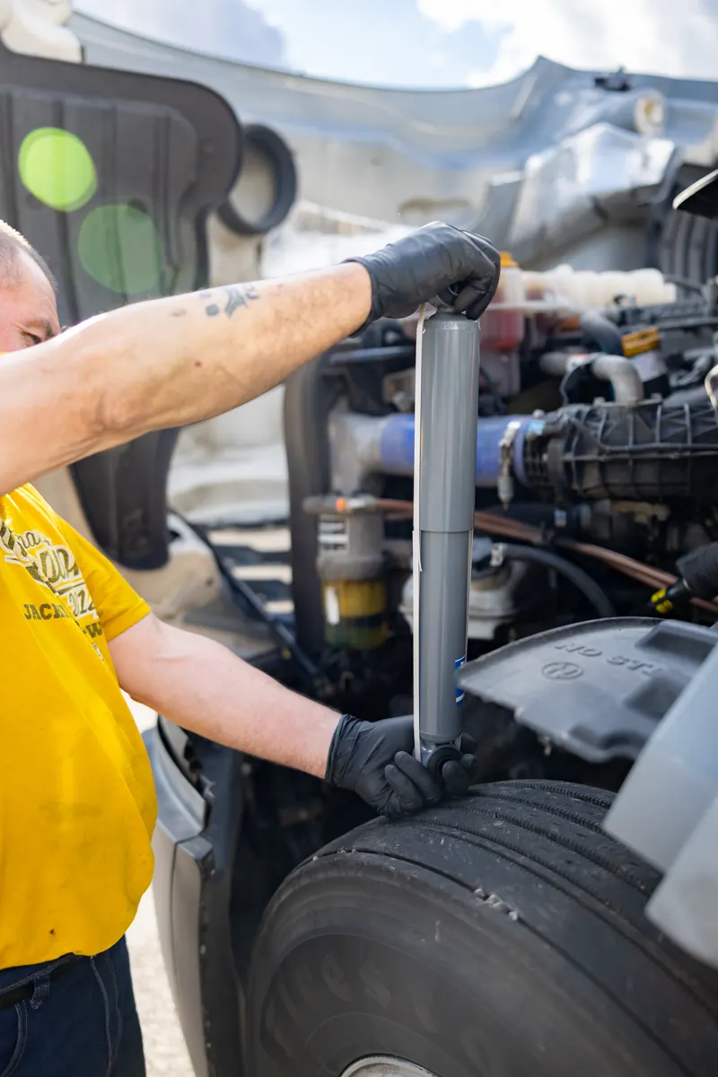Technician working under the hood of a semi truck